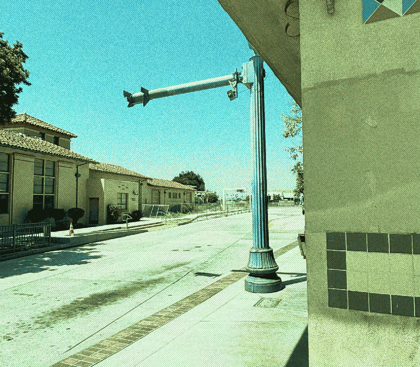 a stucco electrical substation and a more retro-styled overhead charger with a rounded fluted shape